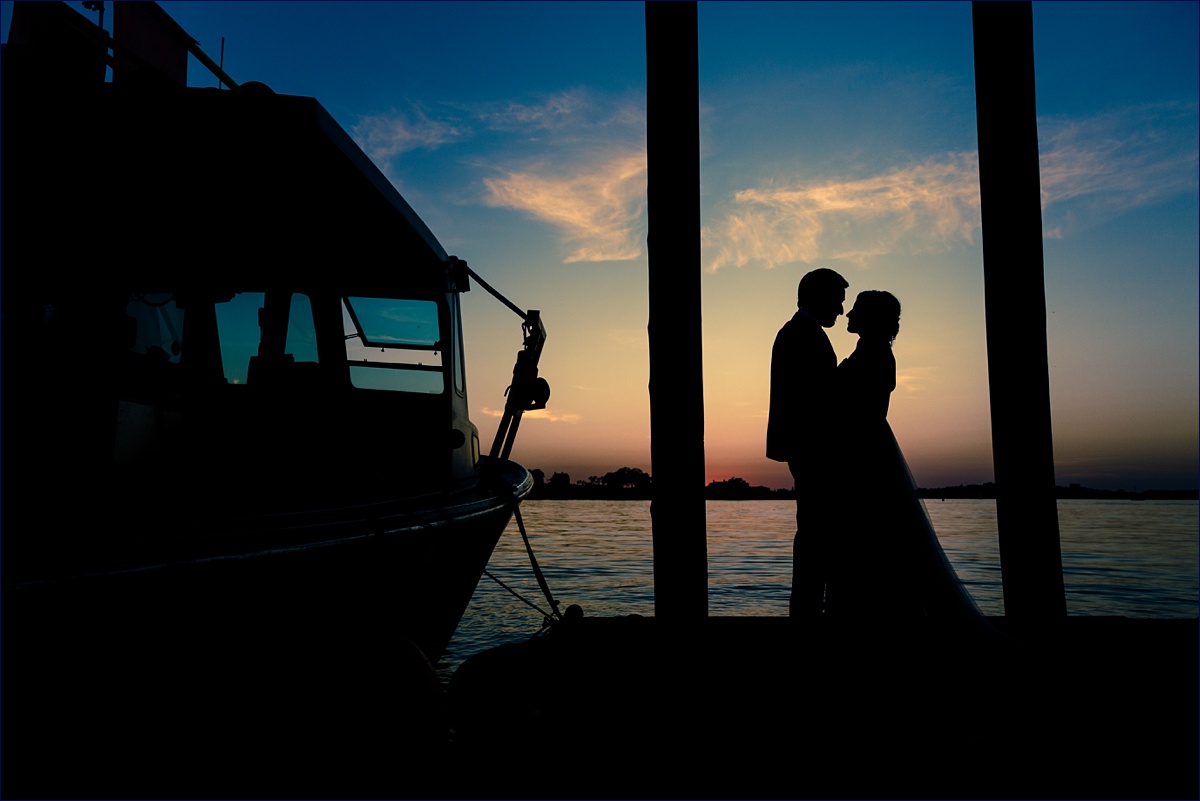 Maine Peaks Island wedding the Bride and Groom Silhouette on the dock overlooking the city of Portland
