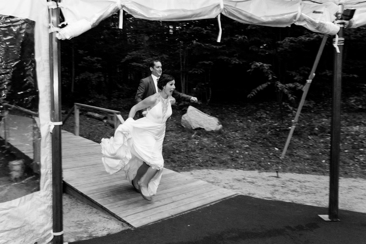 Maine Hardy Farm wedding bride and groom running into their reception under the tent
