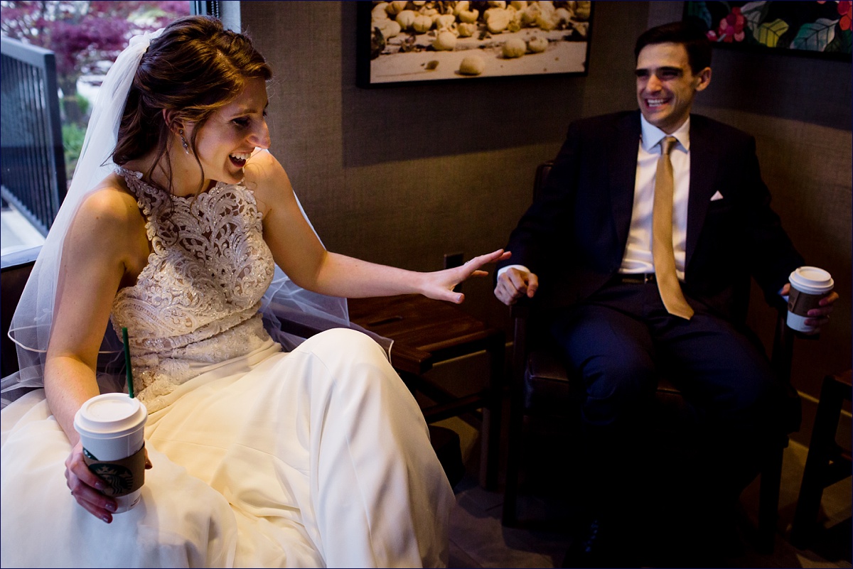 The bride and groom laugh together at a Starbucks after their intimate wedding ceremony