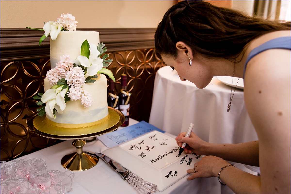 The maid of honor signs the guest book at her brother's wedding reception at 555