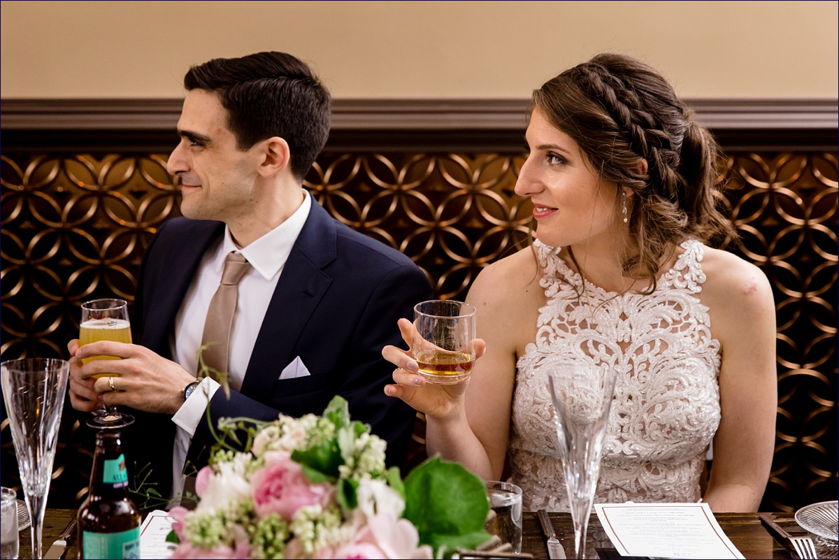 The bride and groom listen as their maid of honor gives a toast at their intimate reception at 555