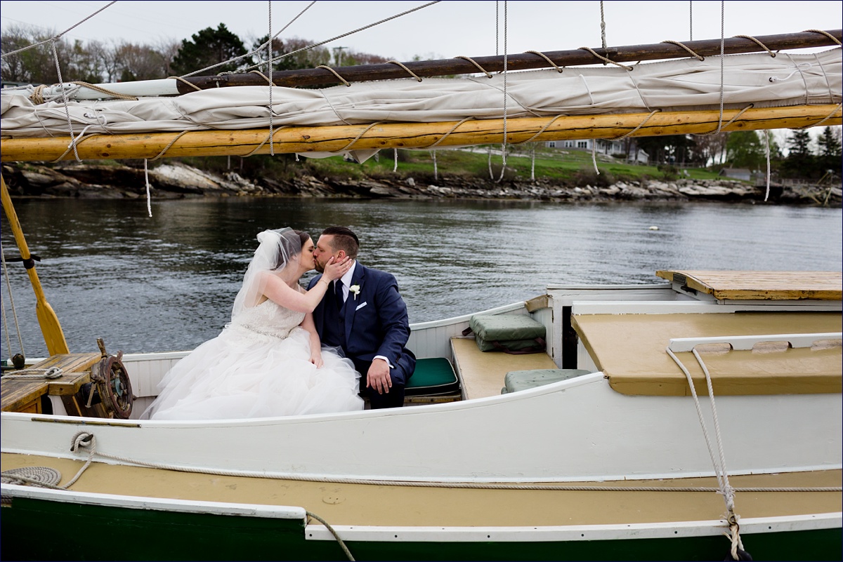 Boothbay Harbor Maine Wedding the bride and groom share a kiss on a sailboat on their wedding day