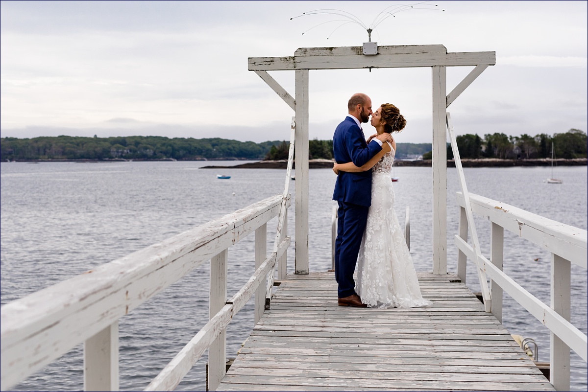 Linekin Bay Resort Wedding Photographer in Boothbay Maine the bride and groom embrace on their first look out on the dock