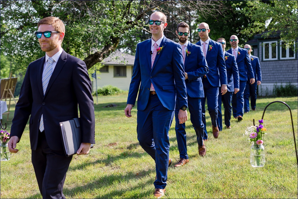 The groom and groomsmen enter into the outdoor NH ceremony