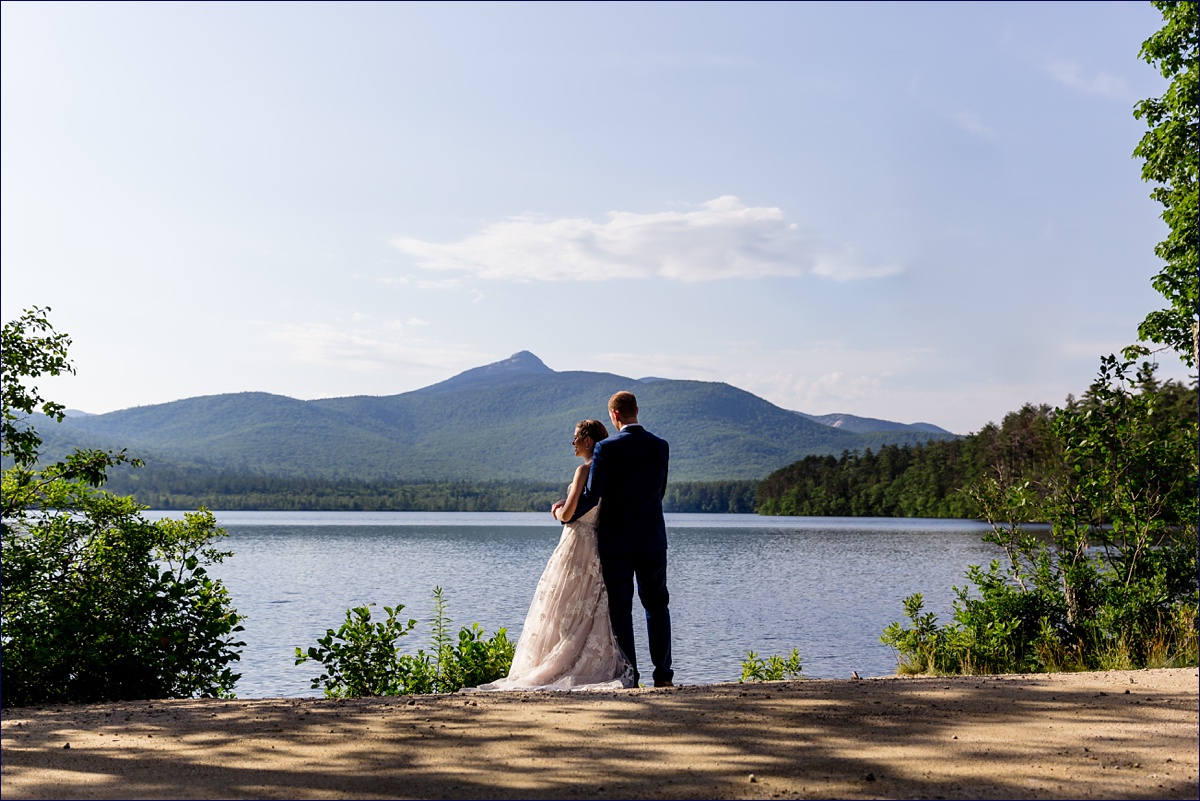 Preserve at Chocorua New Hampshire Wedding the bride and groom in front of Mt Chocorua on their wedding day and cuddle in close