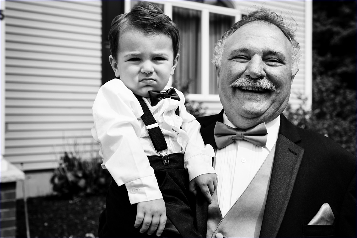 The bride's dad holds his grandson who smirks at the camera