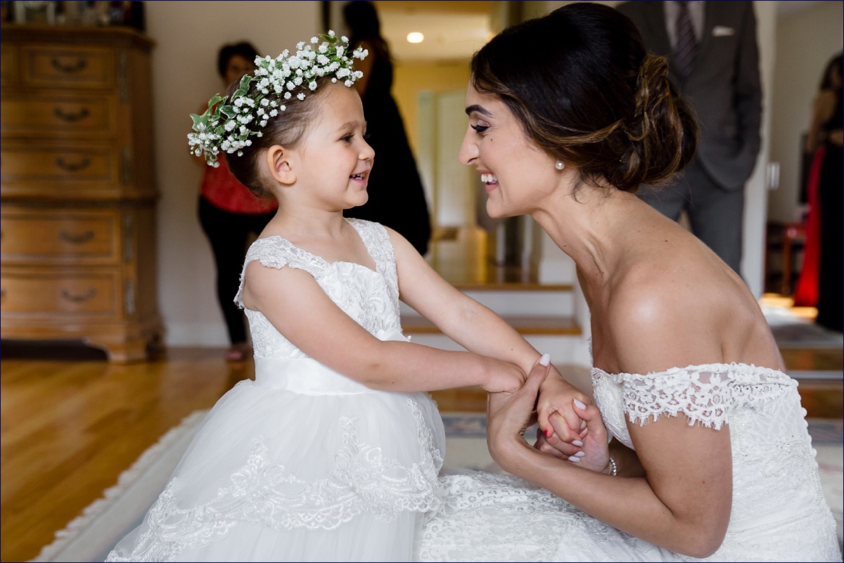 The bride and her flower girl share a laugh on the wedding day