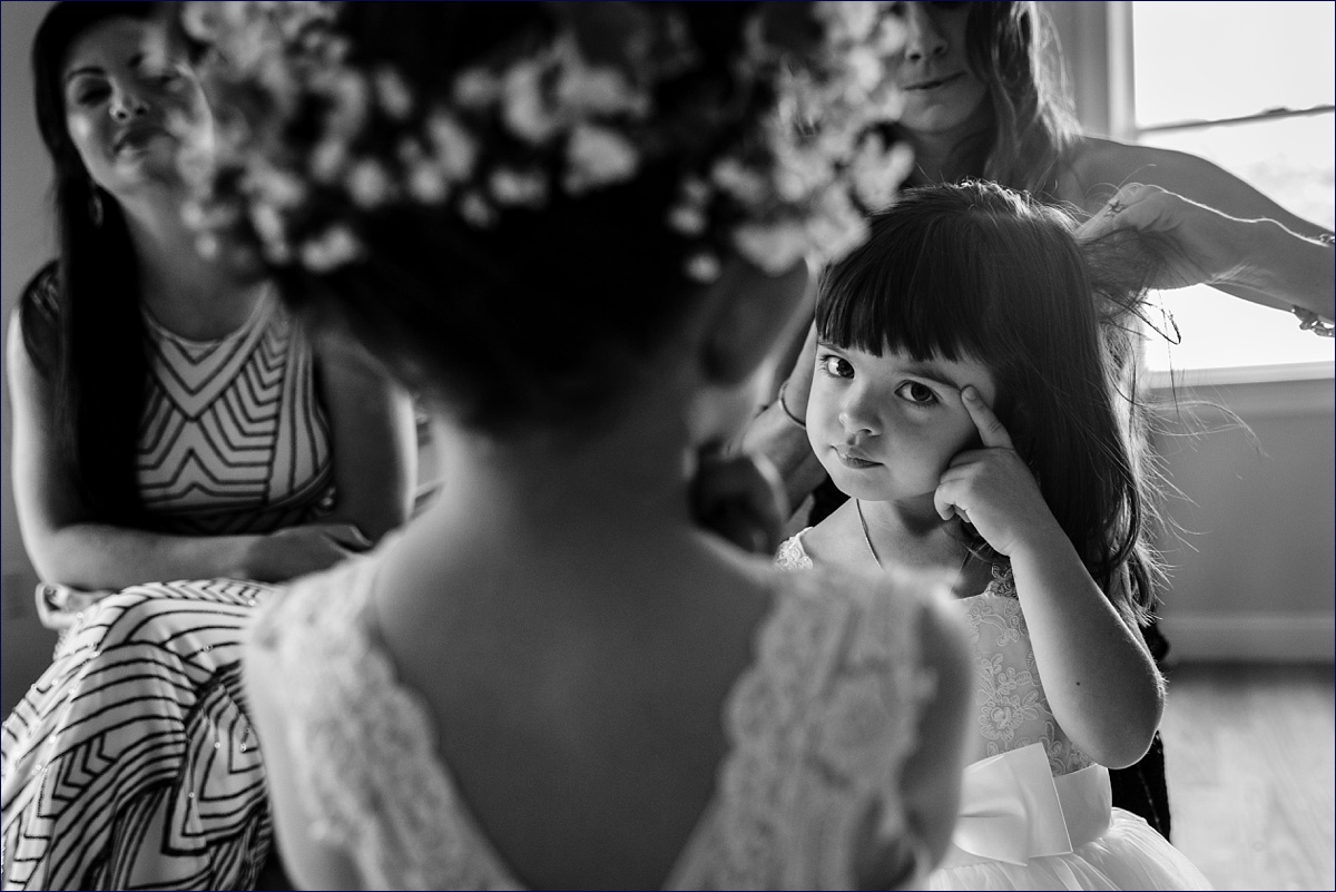 The flower girl is not impressed with having to get her hair done on the wedding day