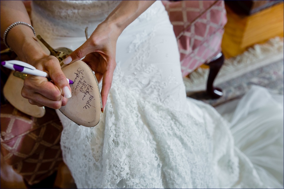 The bride writes the names of the women on her shoe as part of a Greek tradition and custom on her wedding day