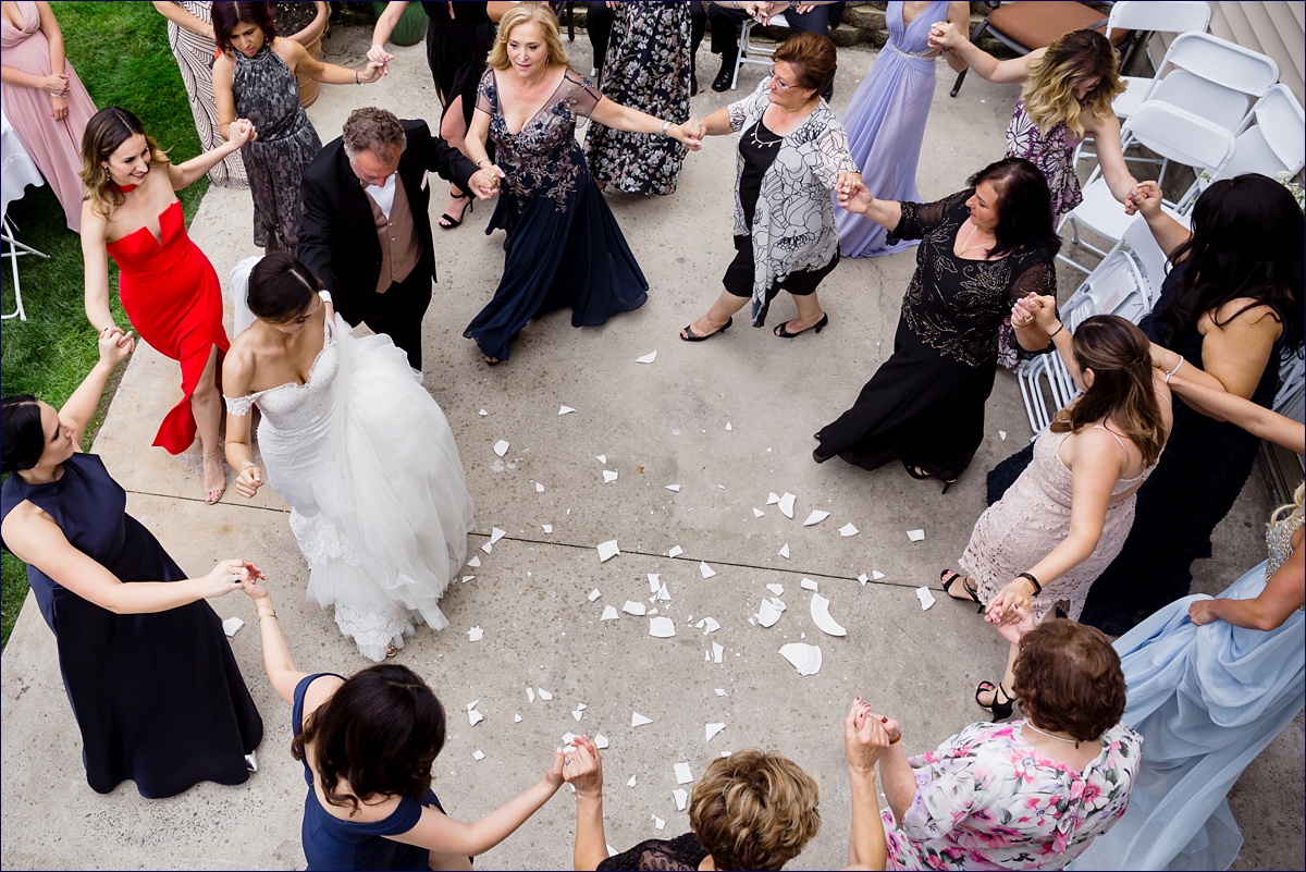 The family celebrates the bride by dancing the Kalamatiano and breaks China plates as part of a Greek tradition and custom on her wedding day