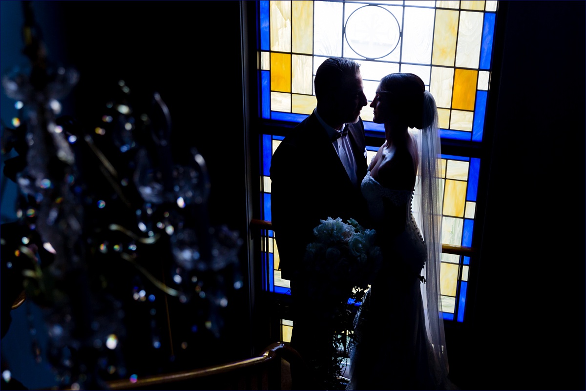 St George Greek Orthodox Massachusetts Wedding Photographer the bride and groom get close in front of the church's stained glass windows on their wedding day