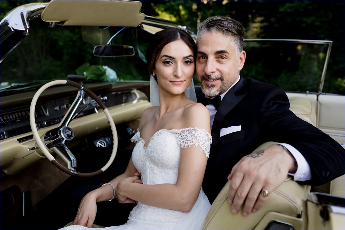Greek Orthodox Massachusetts Wedding Photographer the bride and groom cuddle in a vintage car