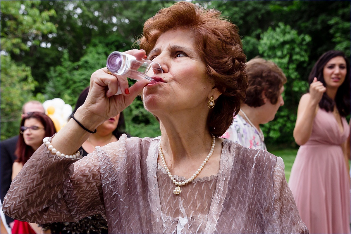 The aunt of the bride celebrates with a shot on the bride's wedding day as part of the Greek traditions and customs