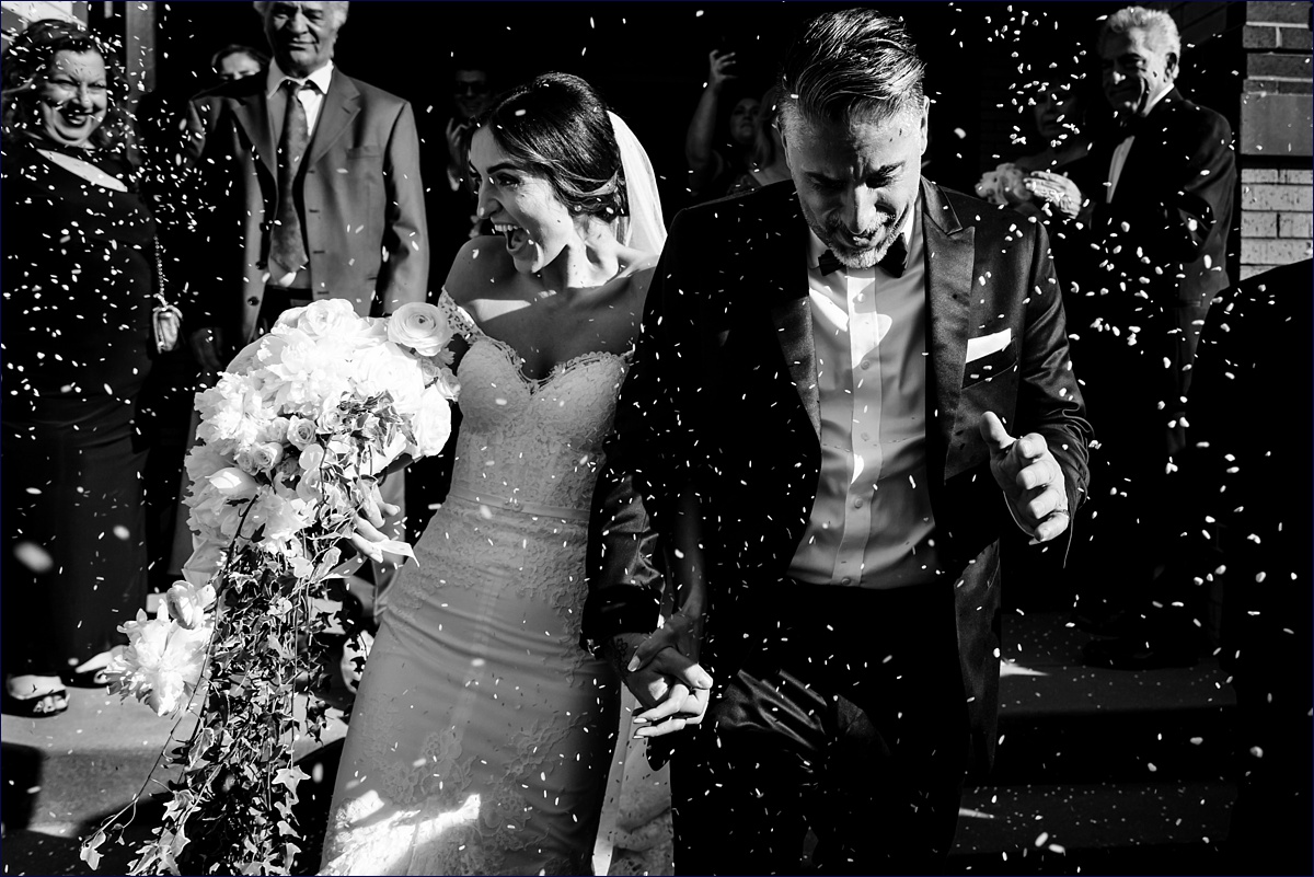 St George Greek Orthodox Massachusetts Wedding Photographer the bride and groom are celebrated with a shower of bird seed on their wedding day outside the church