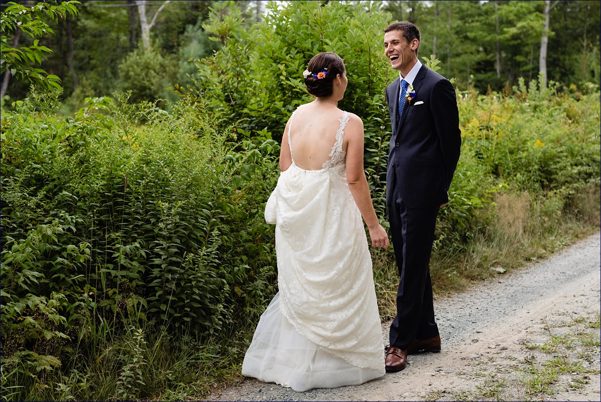 The bride and groom laugh together during their first look in Ellsworth Maine
