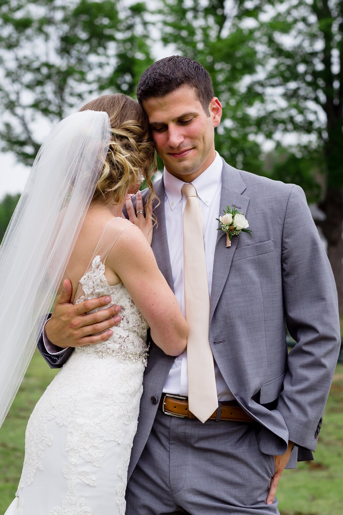 The bride and the groom cuddle in close for wedding portraits