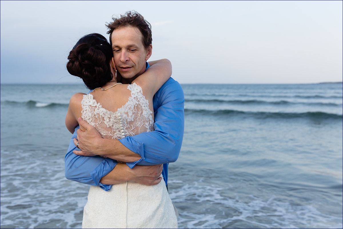 The newlyweds hug each other close after their intimate Maine elopement ceremony