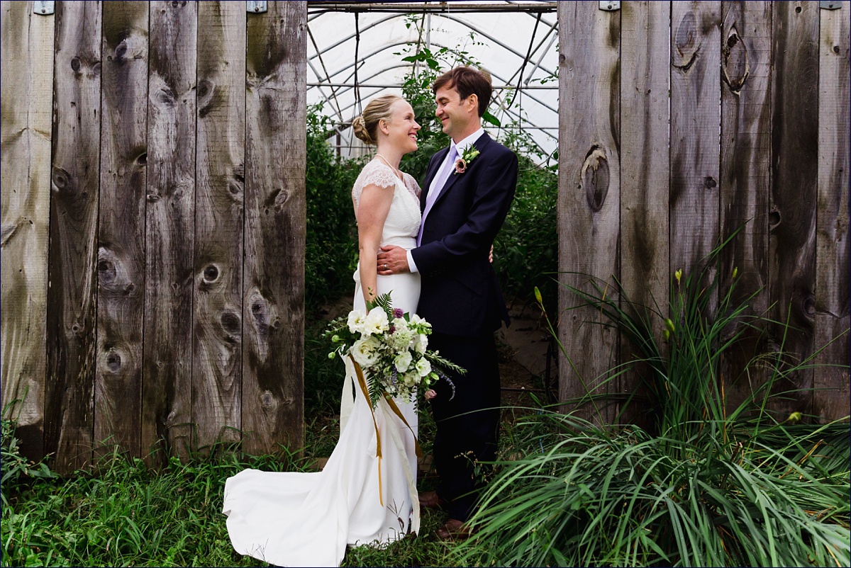 Bride and groom hold each other in front of the farm at Primo Restaurant
