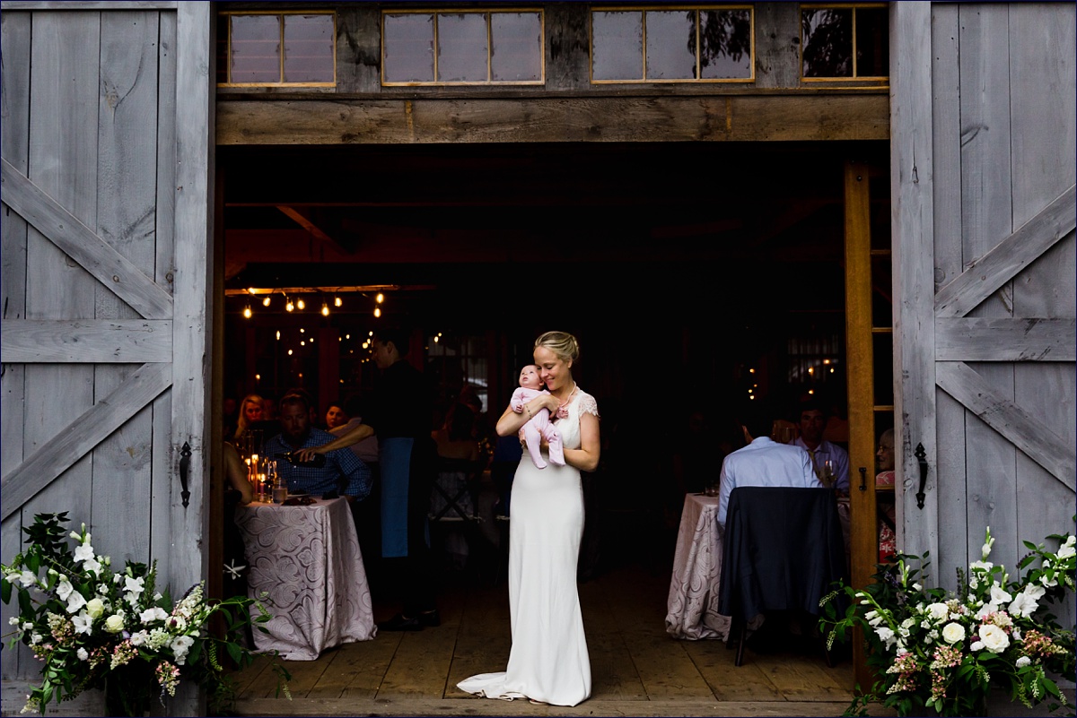 Bride kisses her daughter at the entry of the barn at Primo Restaurant