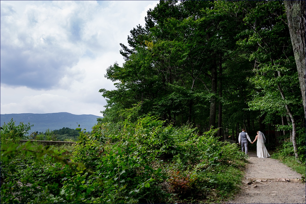 The couple walks through the woods at their New Hampshire camp wedding 