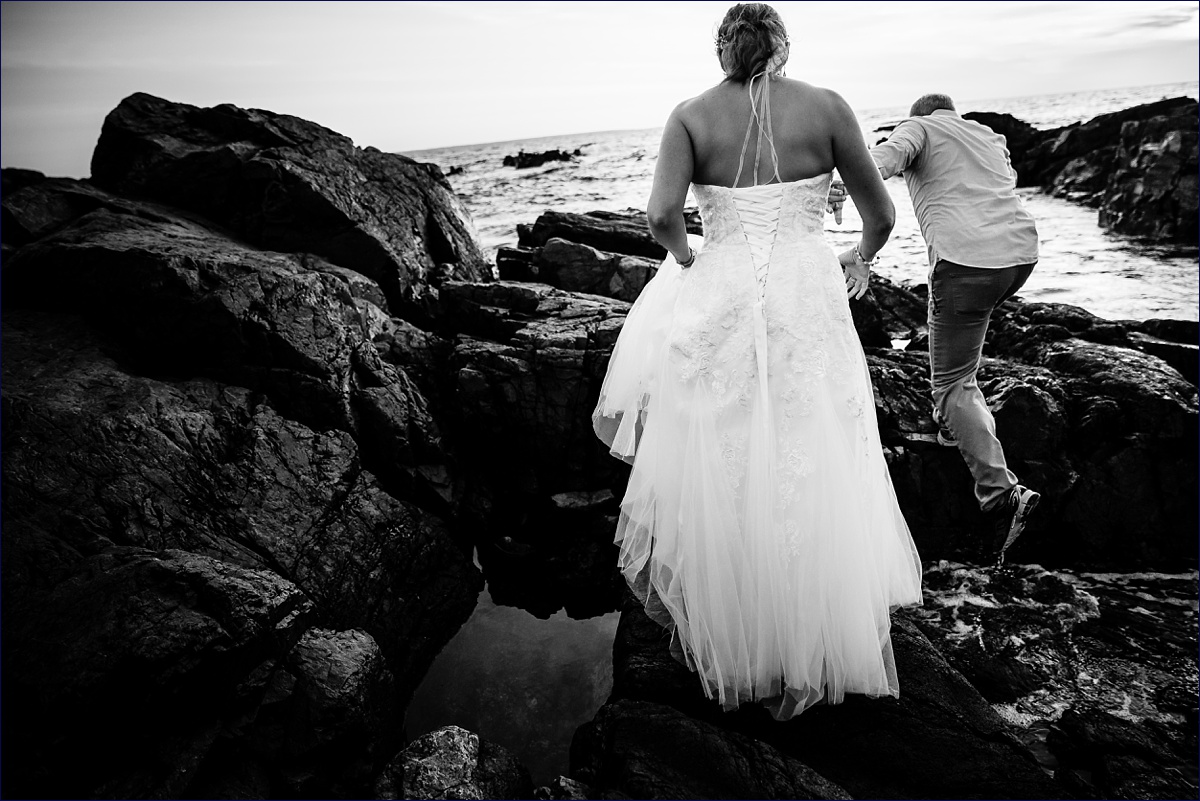 Bride and groom climb out further on the rocks for their elopement pictures