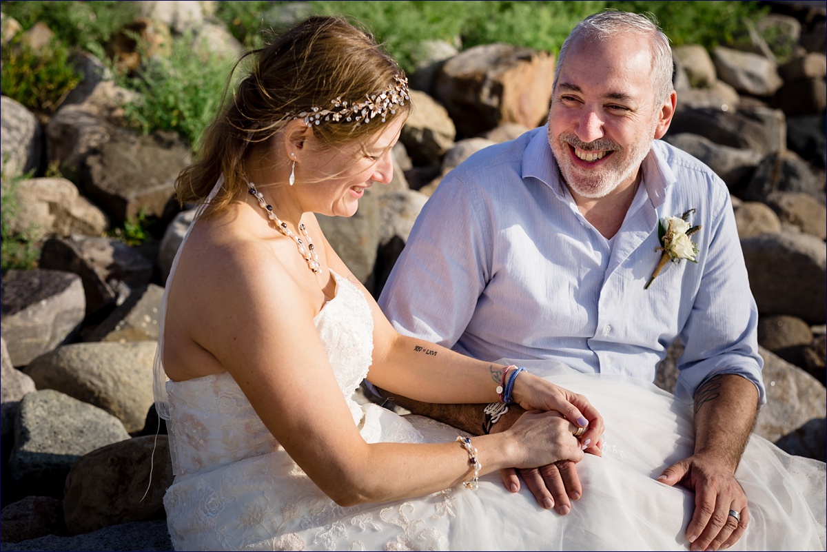 Bride and groom laugh on the rocks at their elopement