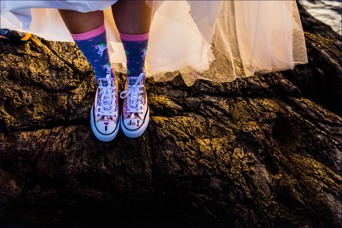 The bride's fancy sneakers and unicorn socks are ready for climbing on the rocks at her elopement