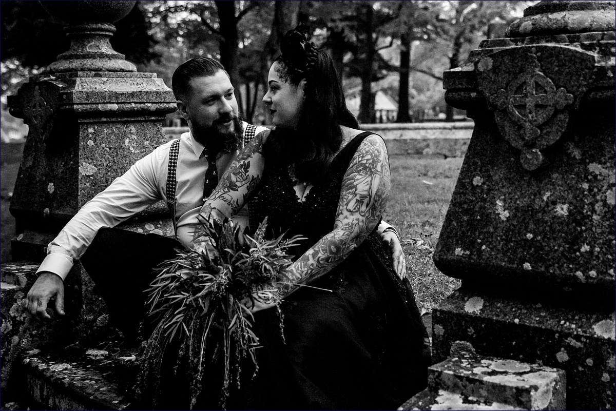 The bride and groom sit amongst the headstones at Pine Hill Cemetery in Dover NH