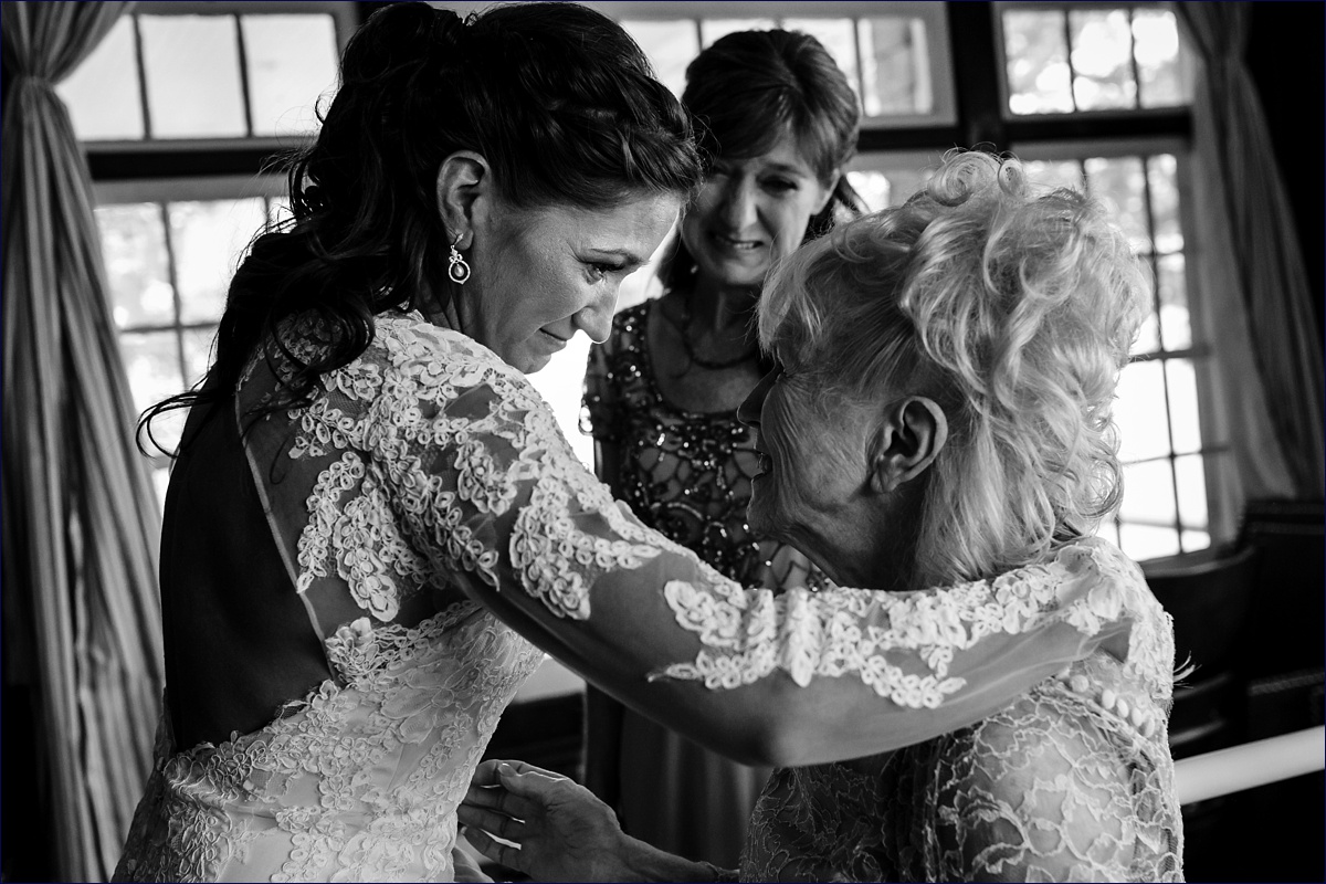 The bride tears up with her mom and grandmother on her wedding day