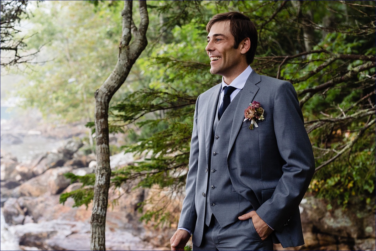The groom smiles in the woods after his ceremony