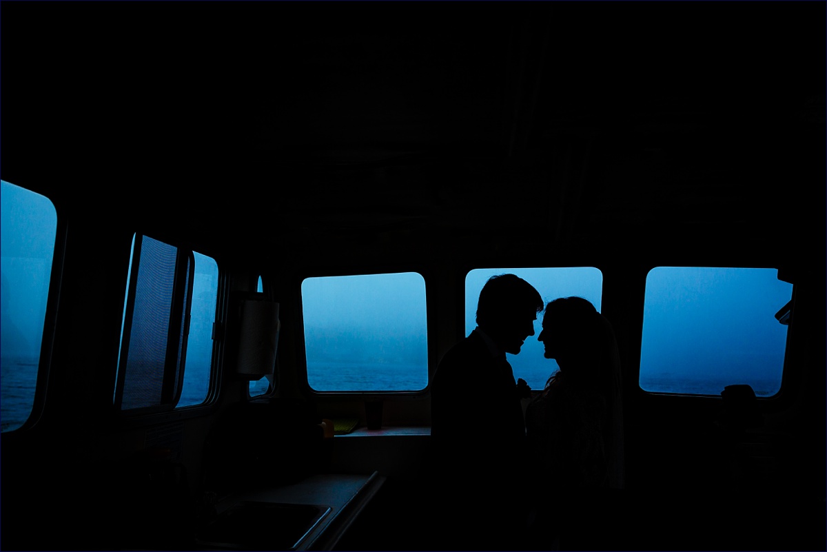 Linekin Bay Resort wedding where the bride and groom are silhouetted against the boat's windows on a foggy day
