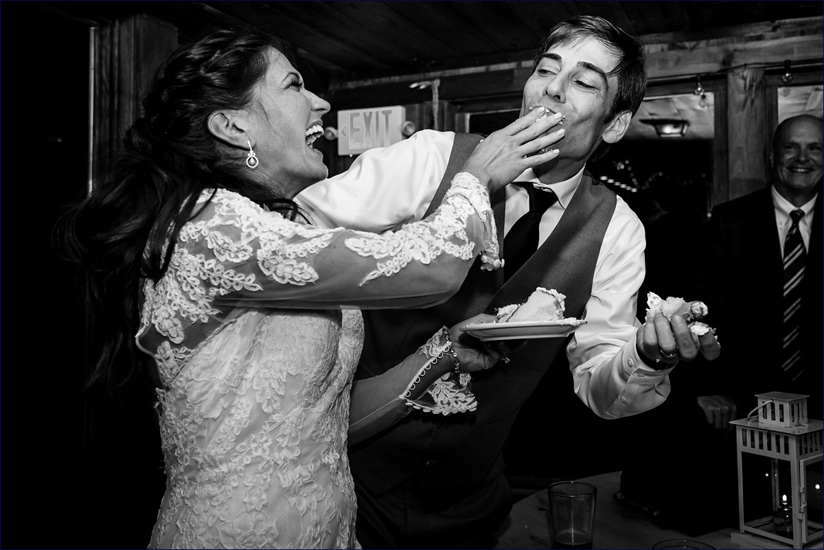 THe bride and groom playfully feed each other wedding cake at Linekin Bay Resort in Boothbay Maine
