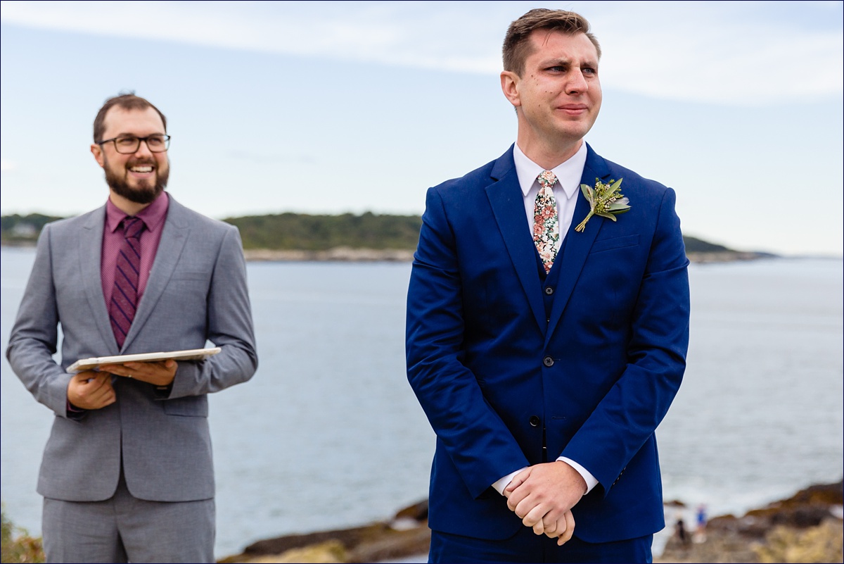 The groom gets emotional as he sees the bride coming down the aisle at their outdoor Fort Williams Maine elopement ceremony