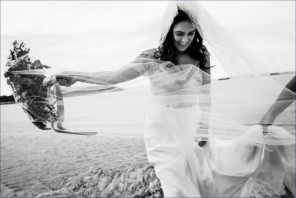 The bride's veil has a mind of it's own on a windy Maine wedding day
