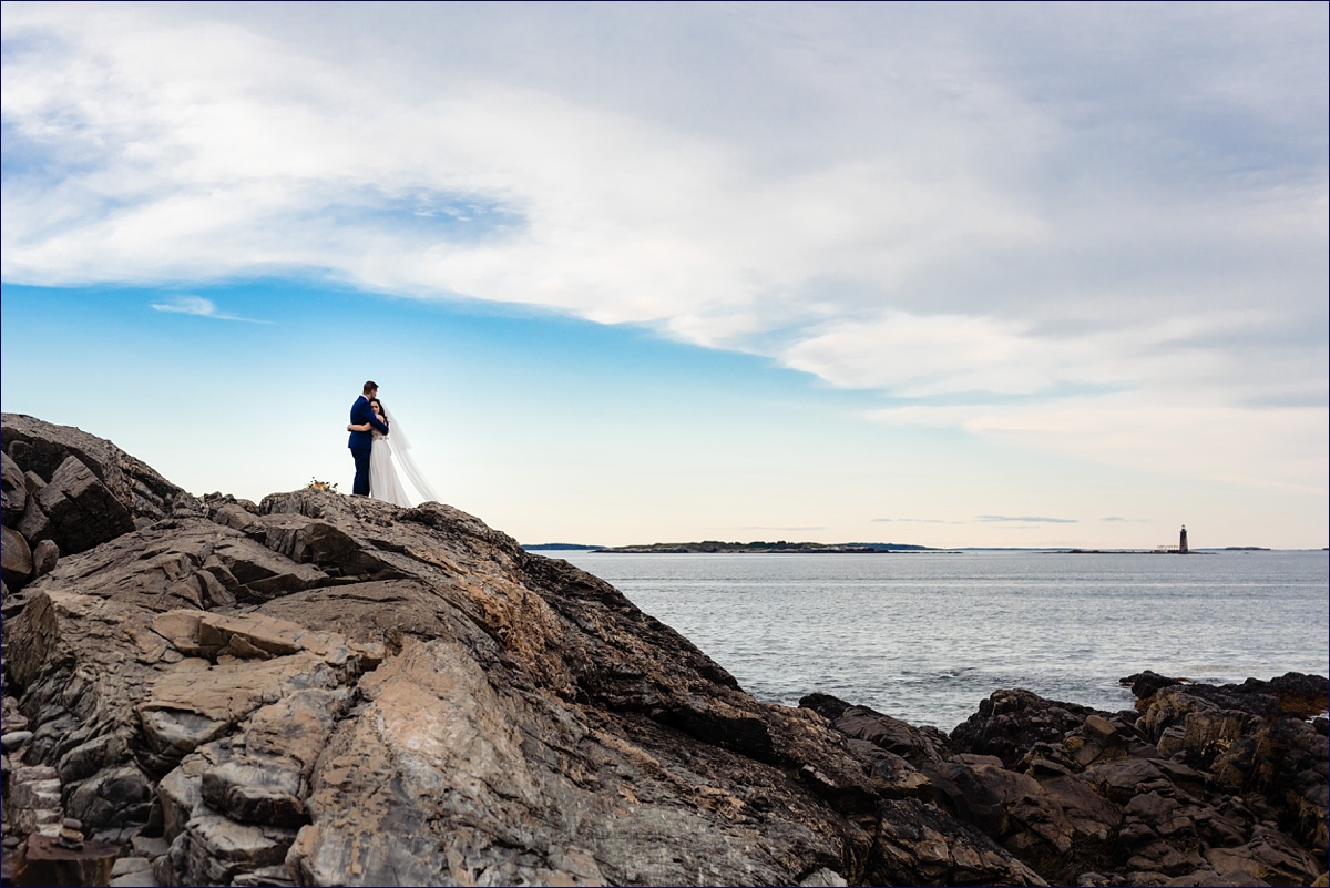 Bride and groom hug on the rocky cliffs in Cape Elizabeth Maine for their elopement