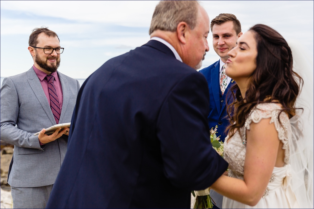 The father of the bride gives away his daughter to the awaiting groom