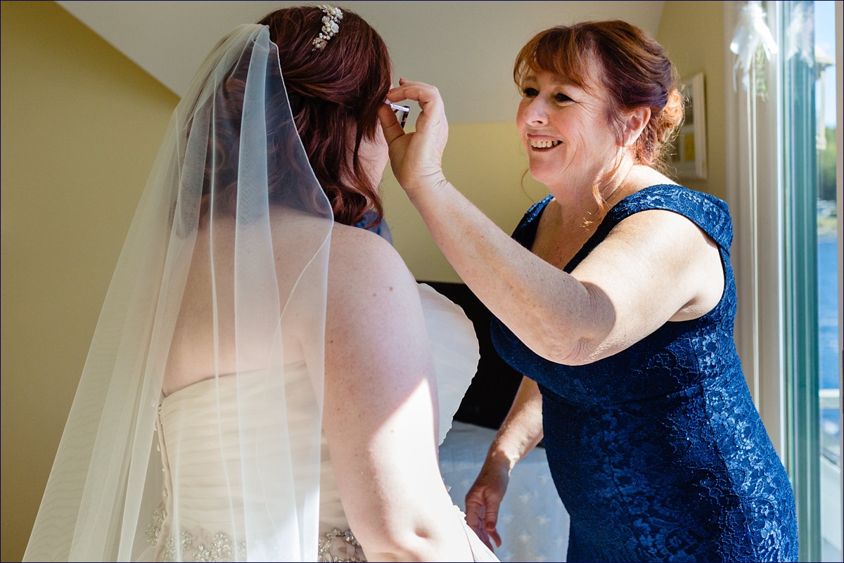 The bride and her mother share a moment together before the ceremony begins in Maine