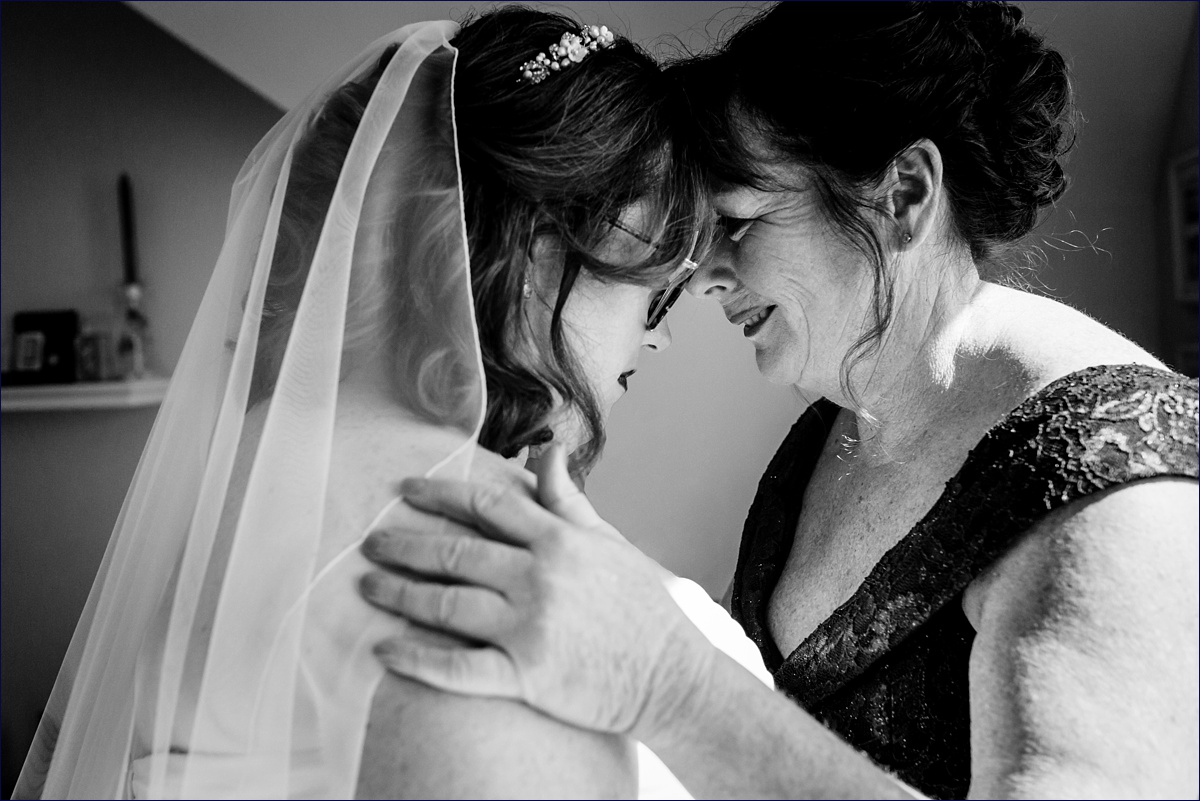 The bride and her mother share a moment together before the ceremony begins in Maine