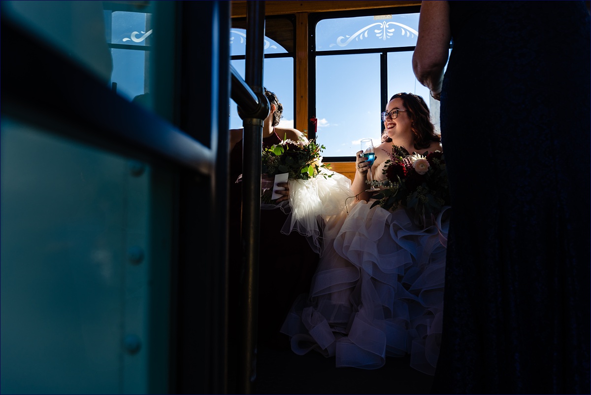 The bride shares a toast on the trolley on the wedding to her wedding ceremony in Boothbay Maine