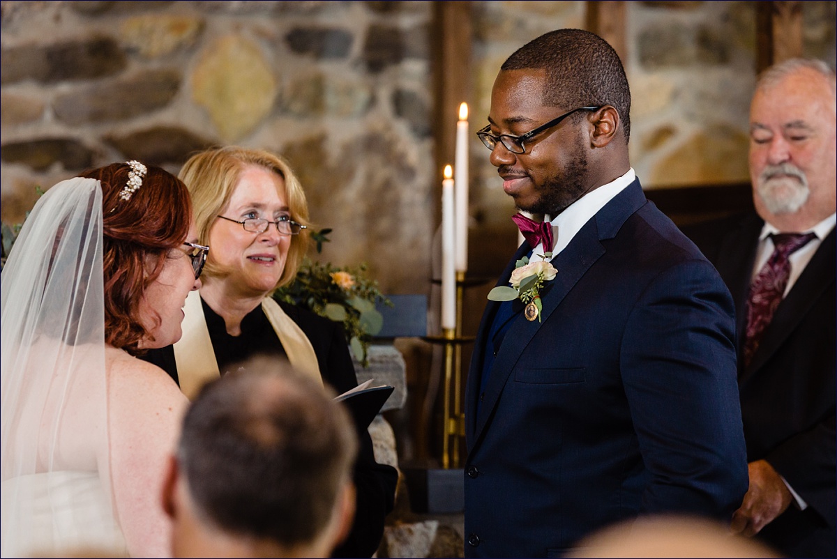 The groom looks lovingly at his bride at his ceremony in a chapel in Boothbay Maine