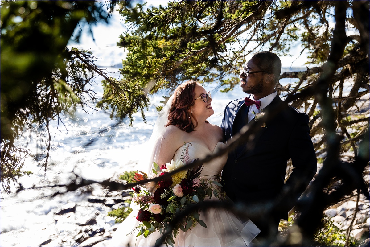 The bride and groom hang out among the trees after their ceremony at Wilson Memorial Chapel in Boothbay Maine