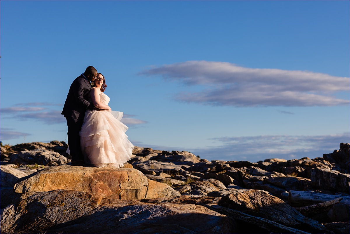 The bride and groom snuggle in close on the beaches of Southport Maine