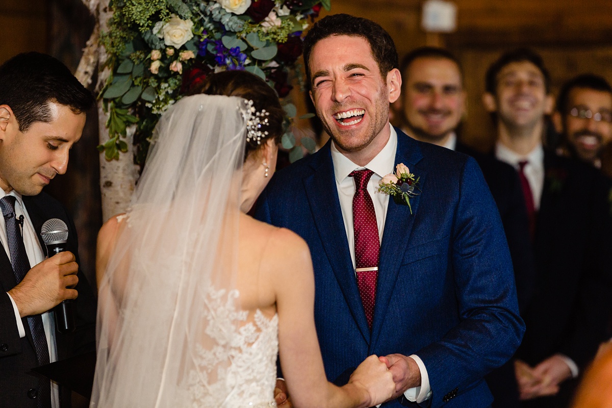 The groom laughs during the wedding ceremony