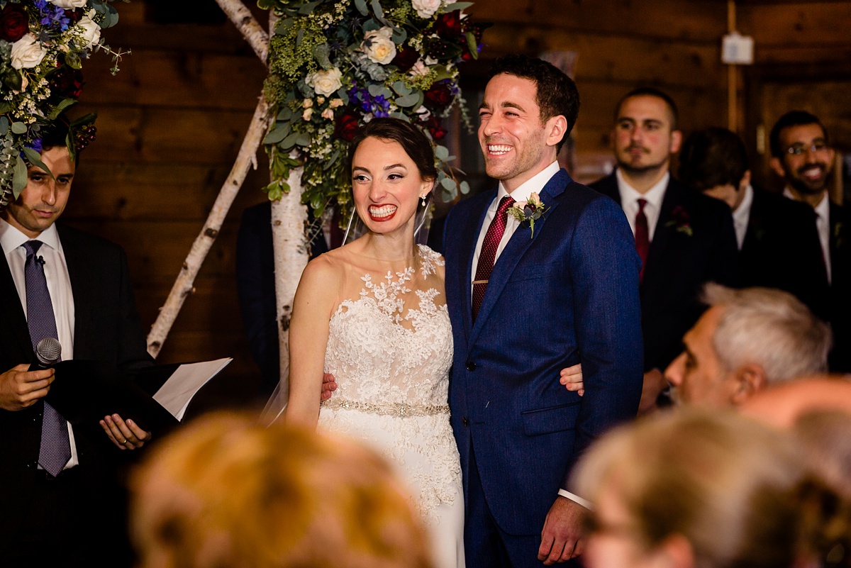 The couple smiles while listening to singers during their wedding ceremony