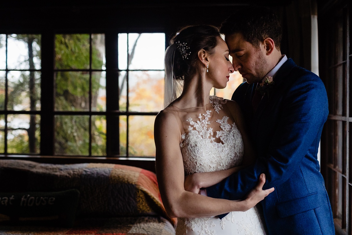 The bride and groom hold onto each other during the snow storm at Migis Lodge Resort in Maine for their wedding