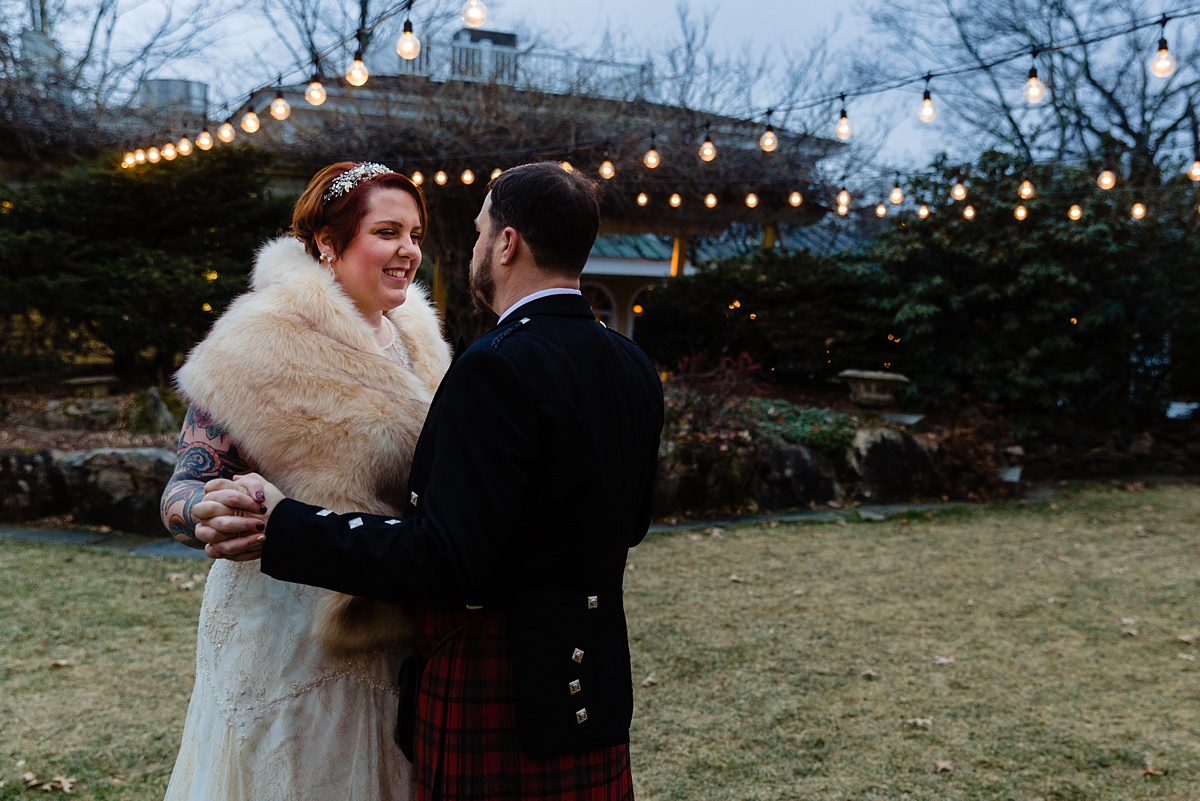The bride gives her groom a warm smile at their chilly December NH wedding