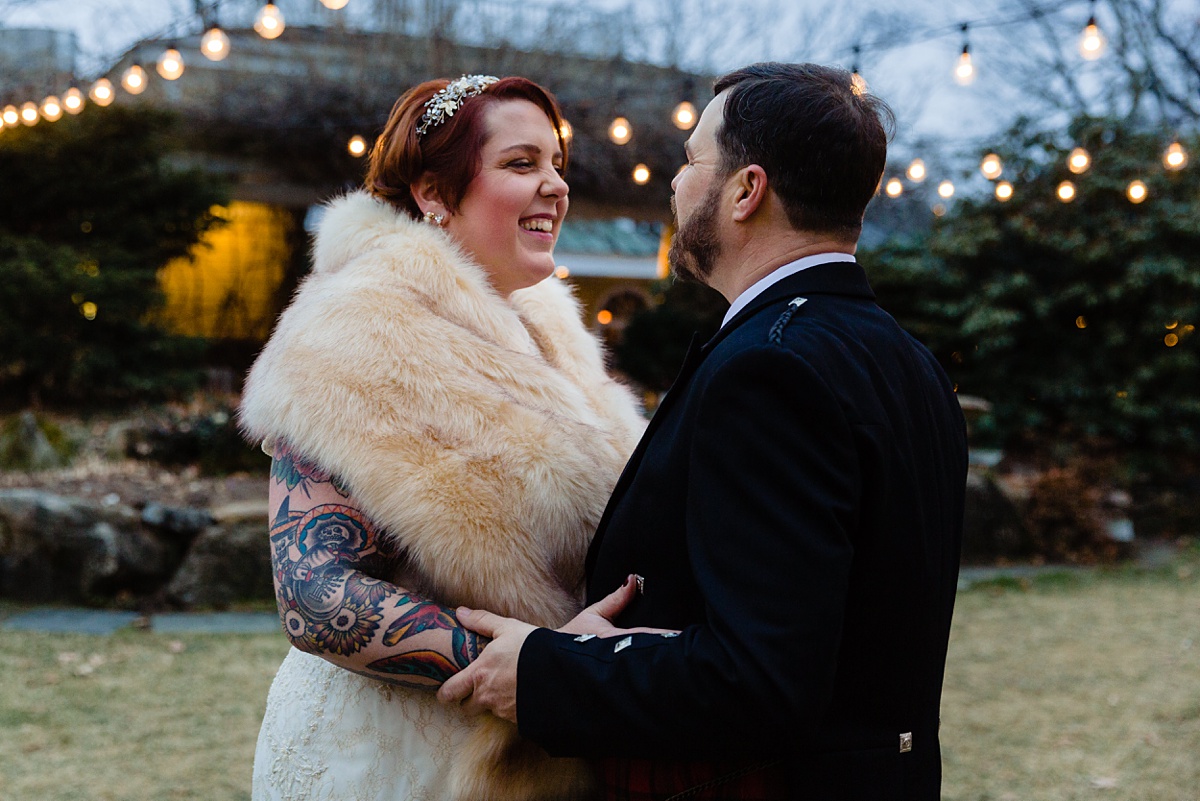 The bride gives her groom a warm smile at their chilly December NH wedding