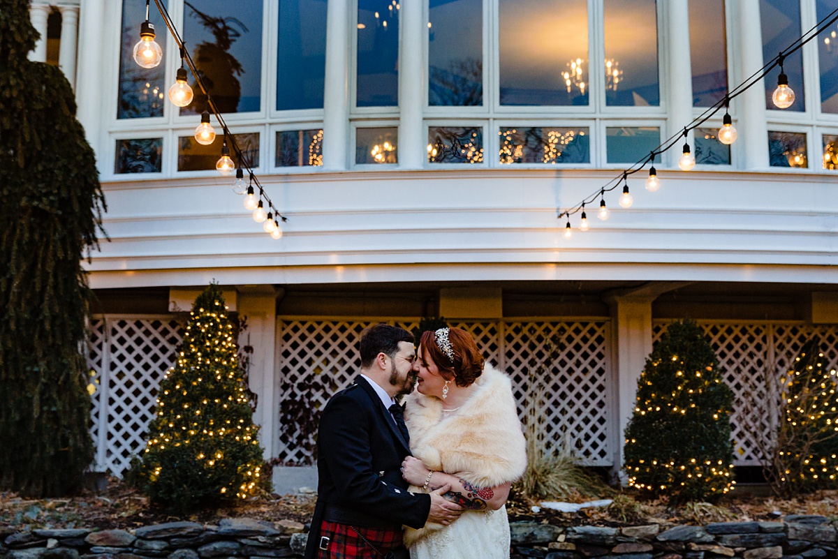 Bedford Village Inn New Hampshire elopement the bride and groom hold each other at their December intimate wedding under the bistro lights