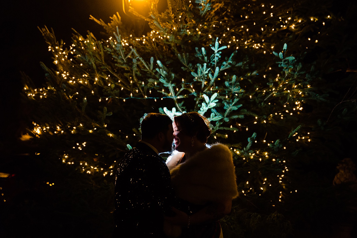 A nighttime photo of the newlyweds in front of the holiday twinkle lights in Bedford NH