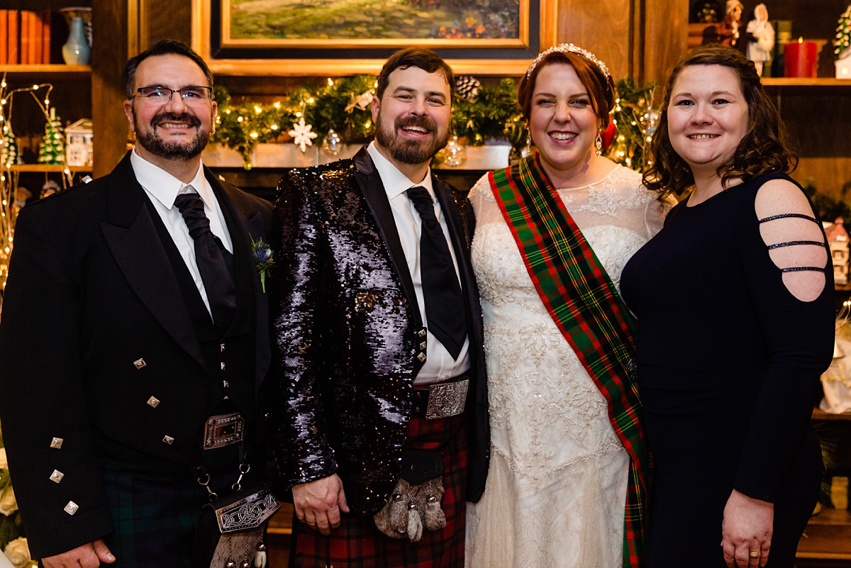 The newlyweds stand with their best friends for a picture in the holiday decorated Tavern at the Inn